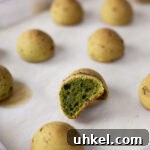 Tray of baked matcha mochi breads with one cut in half.
