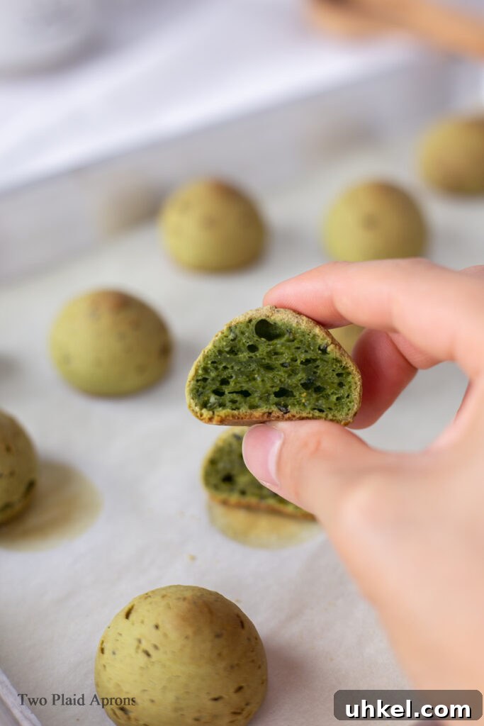 Holding a piece of matcha mochi bread cut in half.