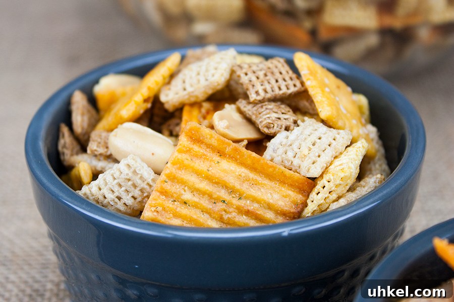 Tangy Dill Pickle Chex Mix Snack Recipe for Parties 11 Spicy Cheddar Snack Mix in a blue serving bowl.