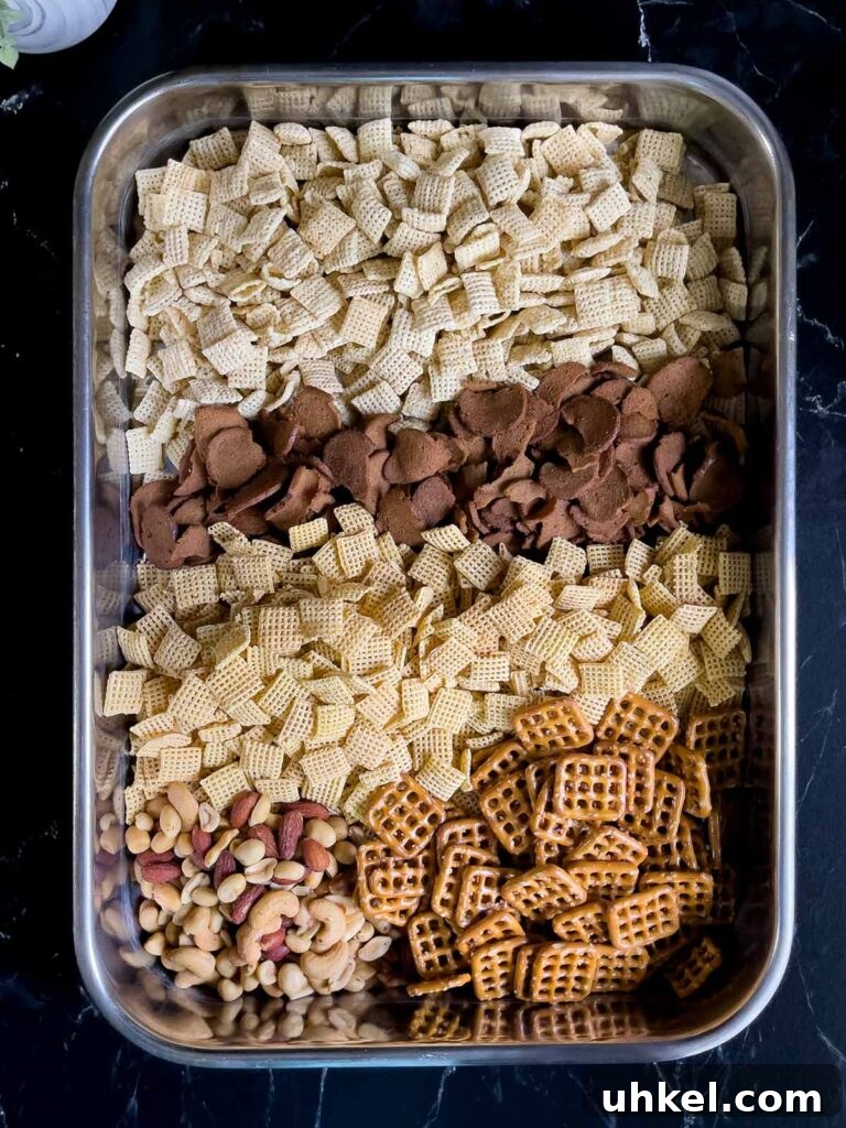 Tangy Dill Pickle Chex Mix Snack Recipe for Parties 4 Cereal ingredients for Dill Pickle Chex Mix in a large baking pan.