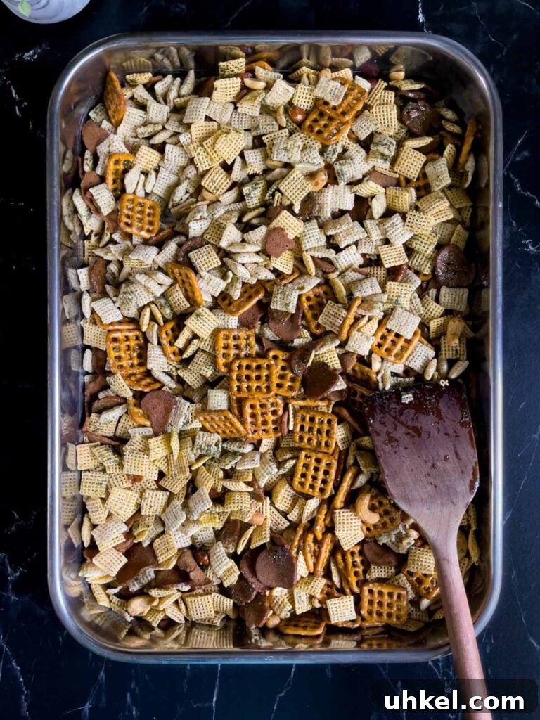 Tangy Dill Pickle Chex Mix Snack Recipe for Parties 6 Unbaked Dill Pickle Chex mix combined with seasonings in a large baking pan.