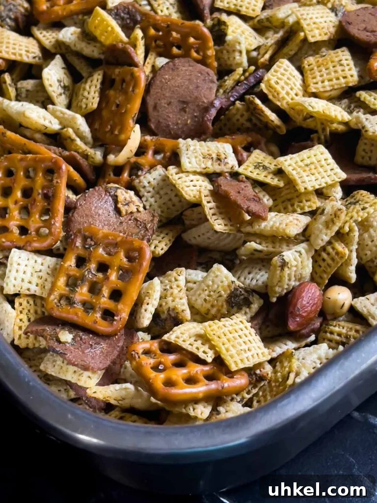 Tangy Dill Pickle Chex Mix Snack Recipe for Parties 7 Baked Dill Pickle Chex mix combined with seasonings in a large baking pan.