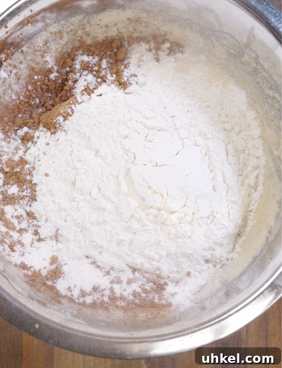 Cocoa powder, flour, baking powder, and salt added on top of glossy brownie cookie batter before gently folding to maintain a fudgy texture.