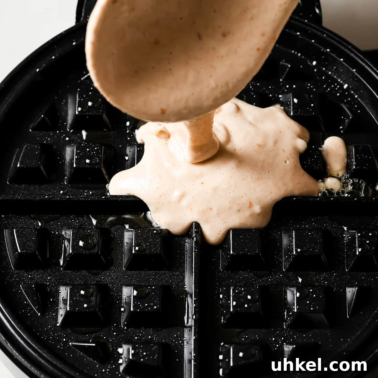 Crispy Peanut Butter Waffles with Maple Syrup 11 Batter going into a waffle maker.