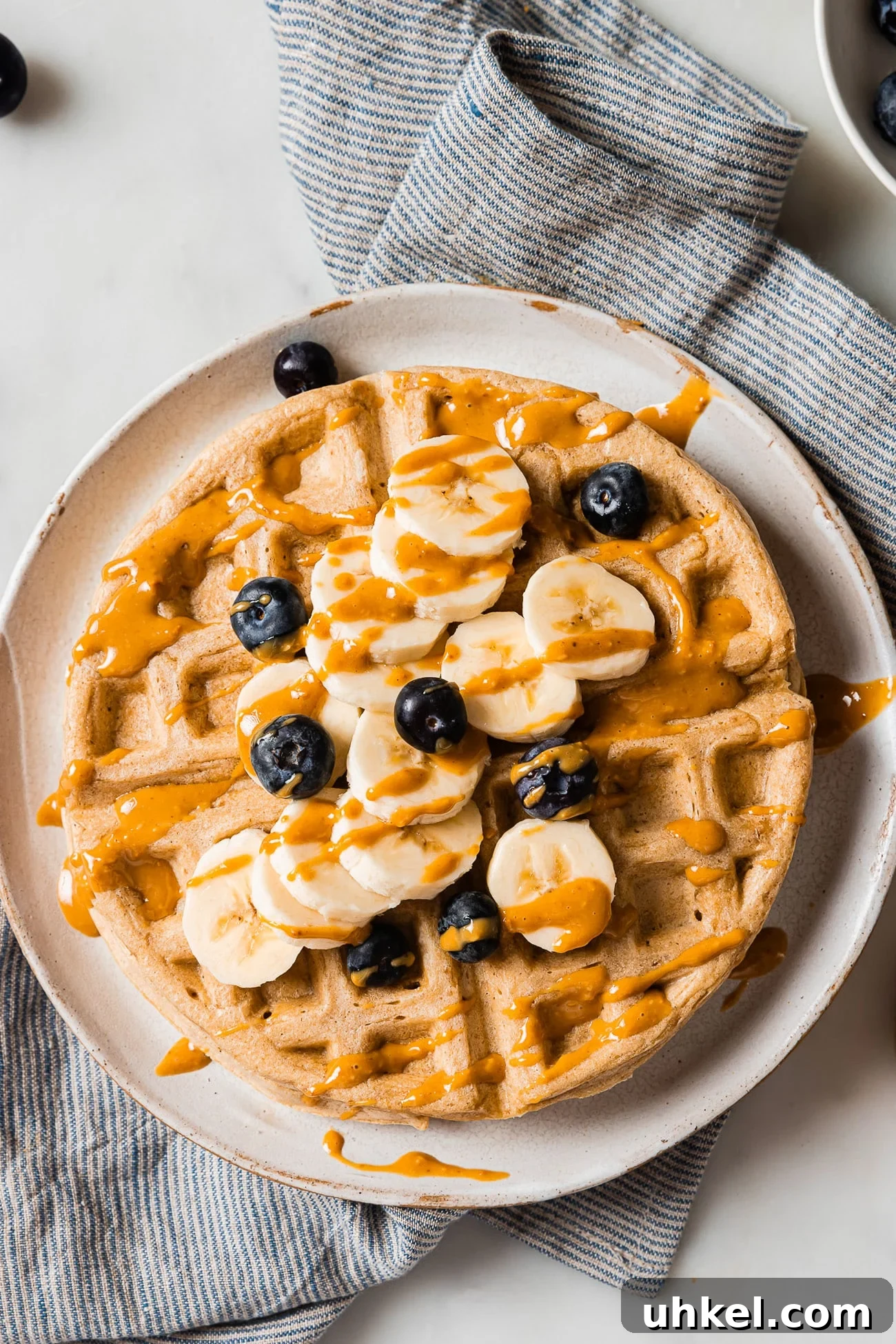 Crispy Peanut Butter Waffles with Maple Syrup 13 overhead view of waffles with berries, slices of banana and peanut butter.