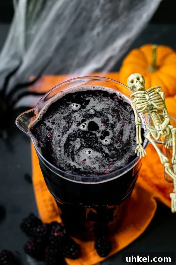 pitcher full of blackberry sangria with a skeleton hanging on the side