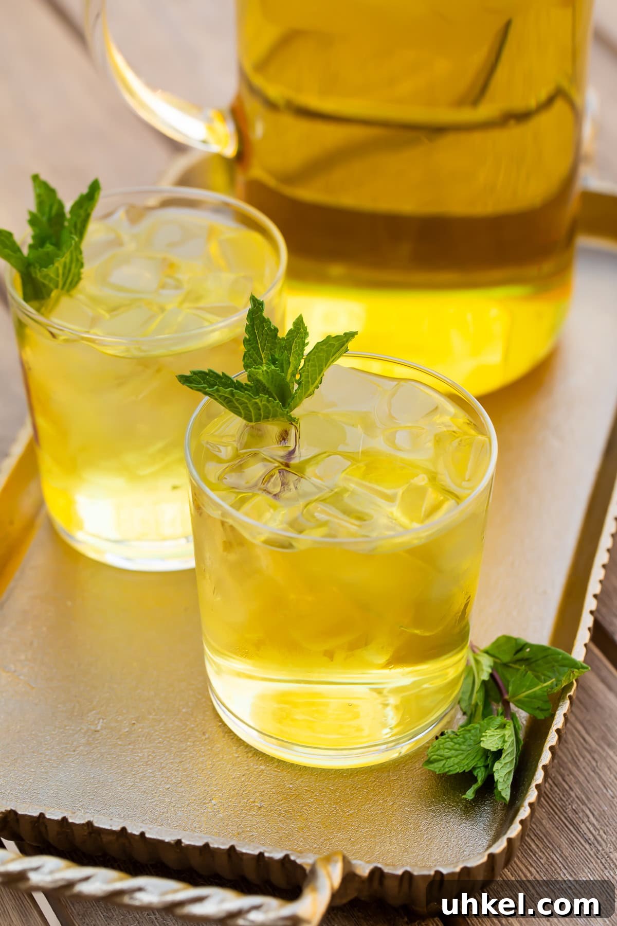 How to Make Cold-Brew Green Tea at Home: Smooth, Refreshing Iced Tea 2 Two glasses of cold brew green tea in front of a pitcher on a table.