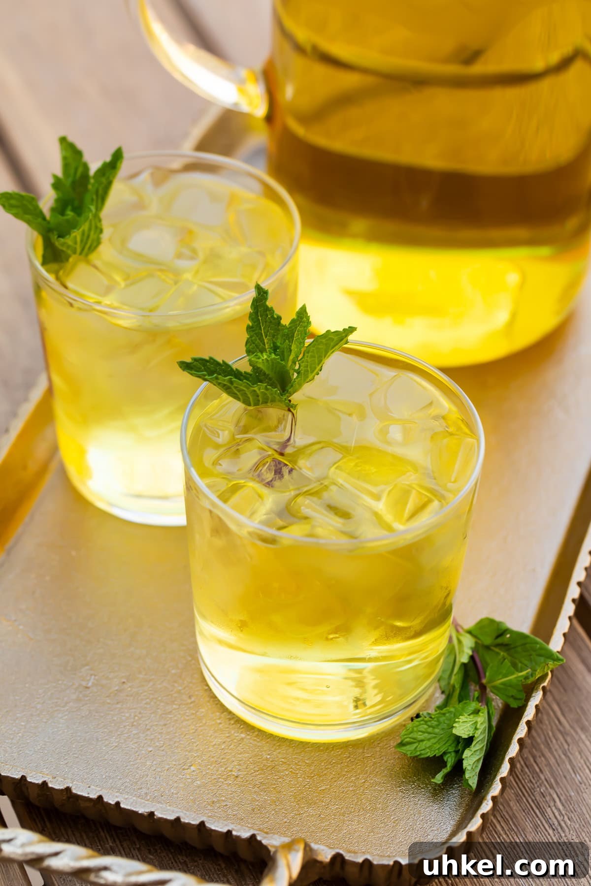 How to Make Cold-Brew Green Tea at Home: Smooth, Refreshing Iced Tea 4 Two glasses of cold brew green tea in front of a pitcher on a table.