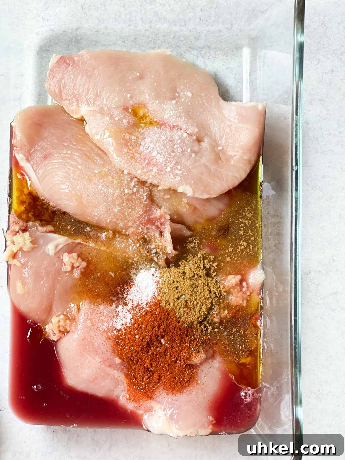 Juicy Mexican-Style Grilled Chicken with Zesty Marinade 5 Mexican spices and chicken in a bowl.