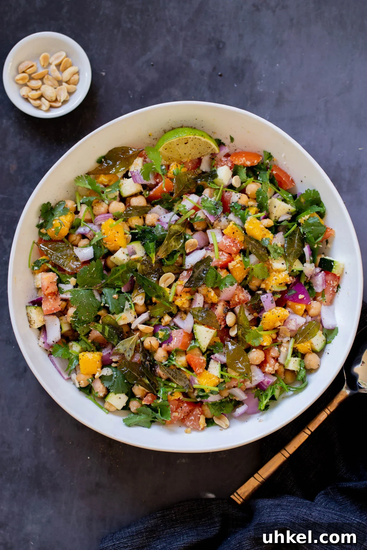 Mango, Chickpea & Zucchini Koshimbir Salad with Curry Leaves 2 zucchini koshimbir salad in a serving bowl with a lime wedge