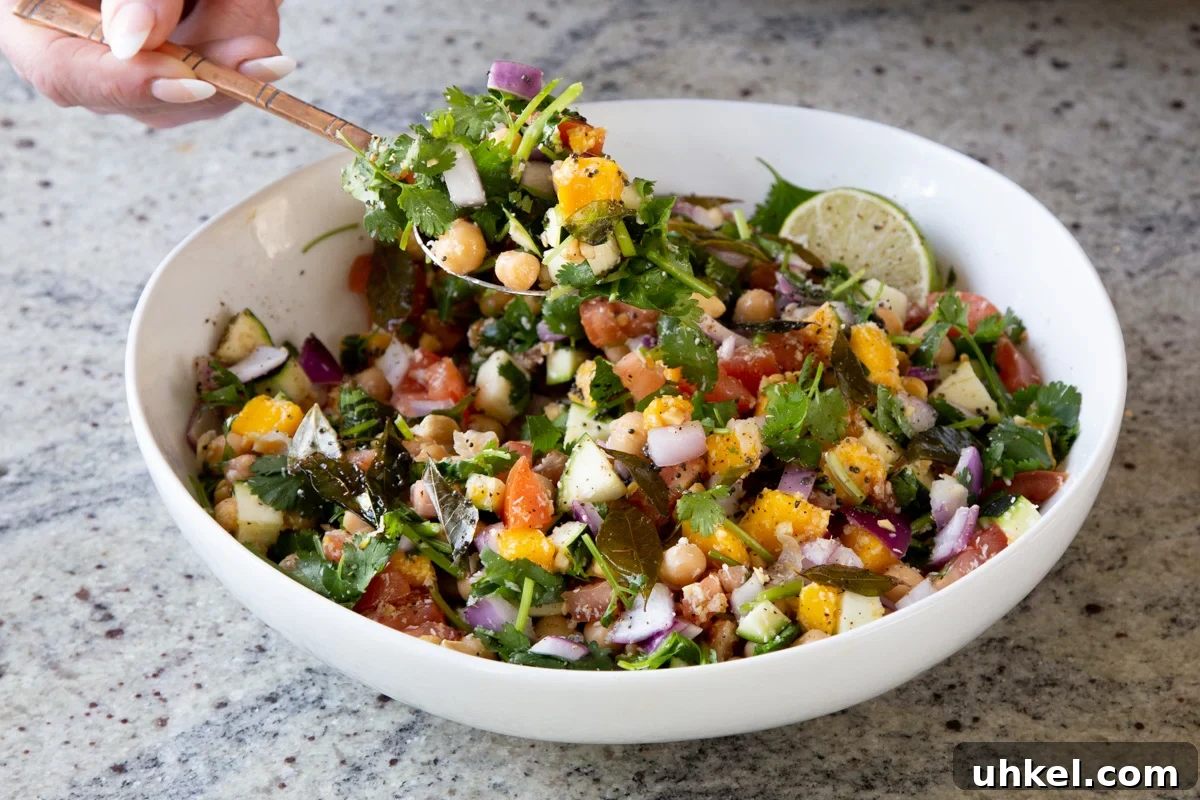 Mango, Chickpea & Zucchini Koshimbir Salad with Curry Leaves 9 scooping up a serving spoonful of koshimbir salad