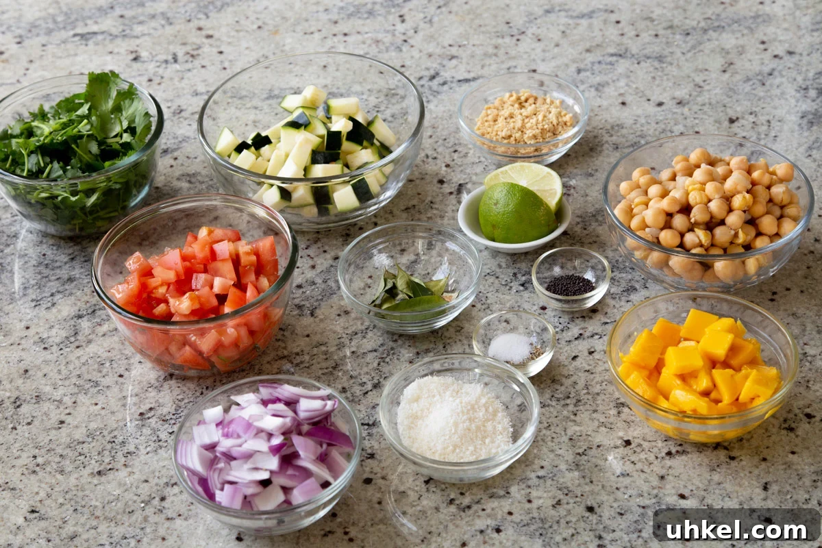 Mango, Chickpea & Zucchini Koshimbir Salad with Curry Leaves 6 veggies, fruit, chickpeas, and seasonings in bowls on a kitchen counter