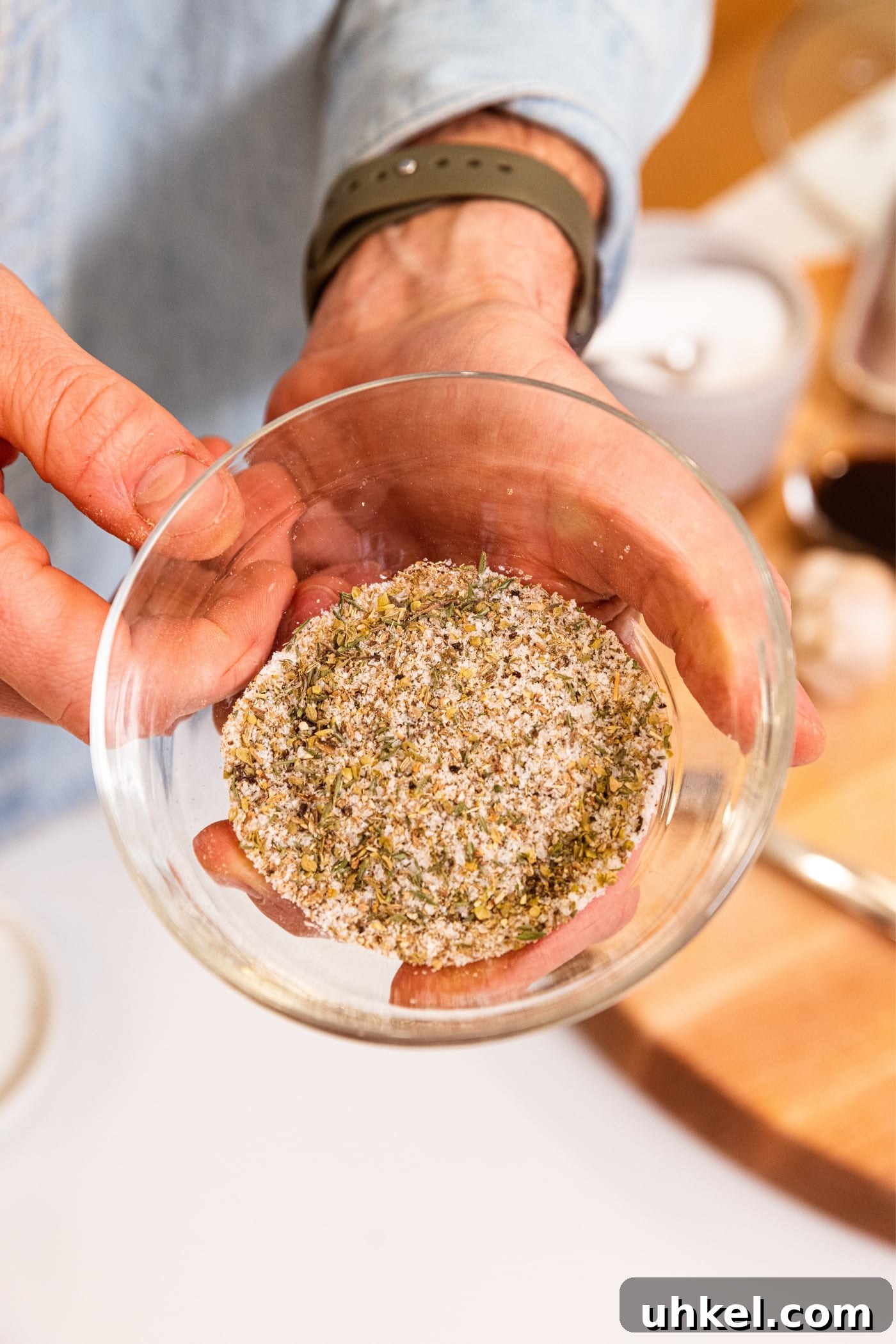 Slow-Cooked Italian Roast Pork Sandwich Recipe 6 Small glass bowl filled with spice mixture with dark and light granules showing through with white countertop underneath.