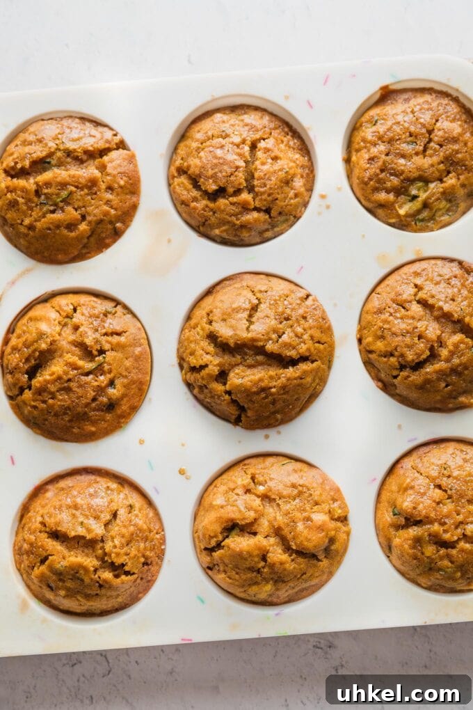 Moist Pumpkin Zucchini Muffins with Warm Spices 10 Silicone muffin baking tin filled with pumpkin zucchini muffins fresh out of the oven.