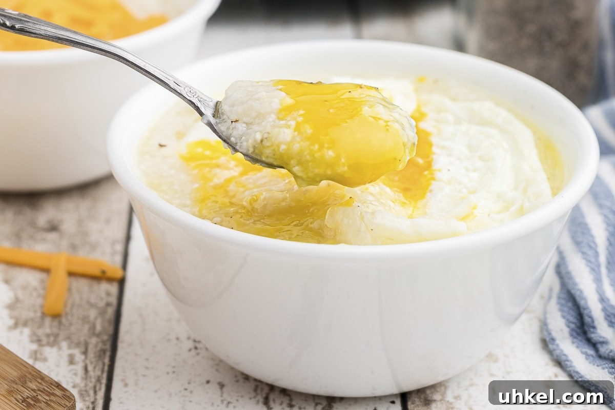 Slow-Cooker Creamy Grits Recipe for Perfectly Smooth Breakfast 6 crockpot grits with cheese on top.