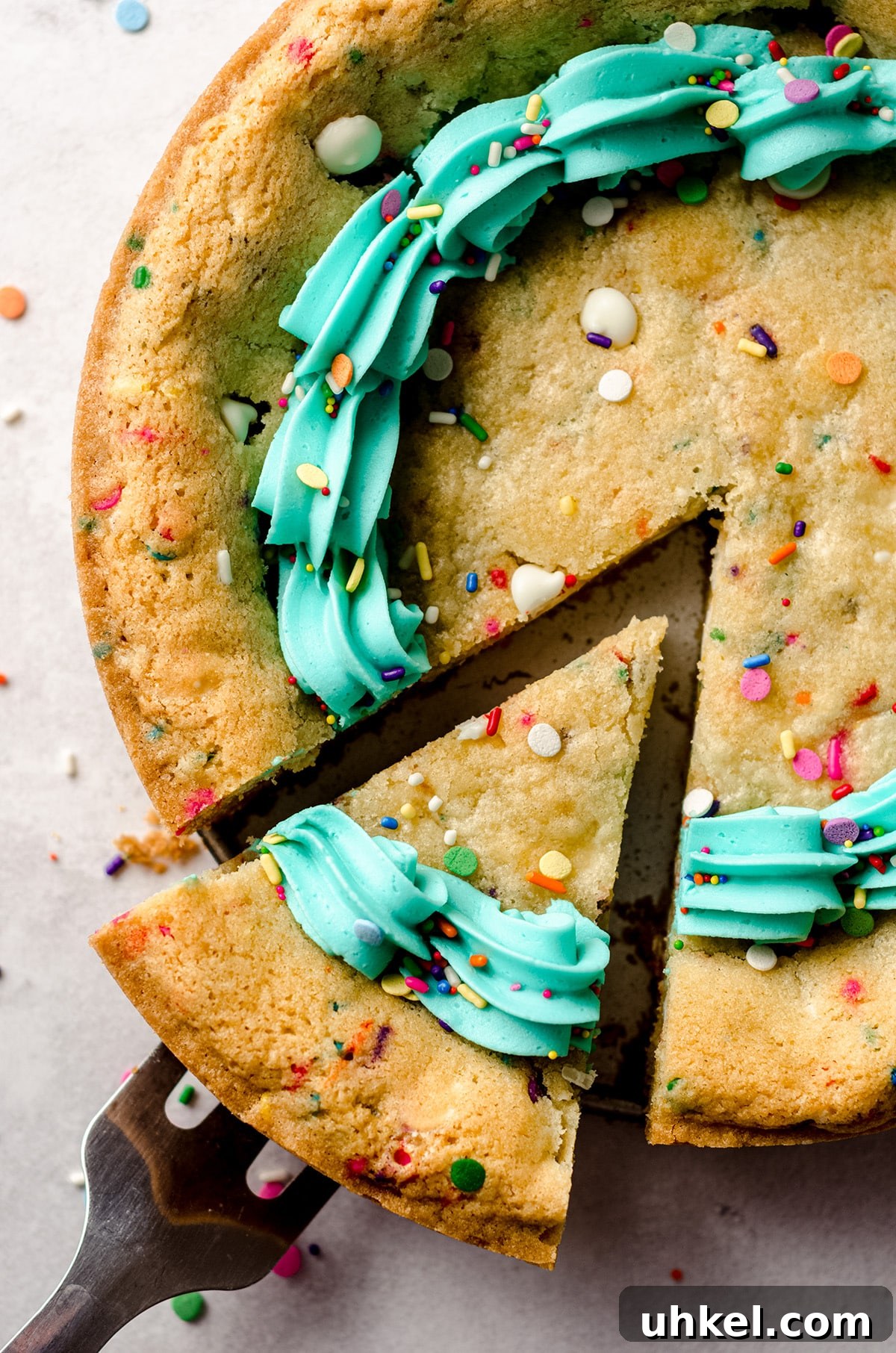 aerial photo of funfetti sugar cookie cake with a slice being taken out of it