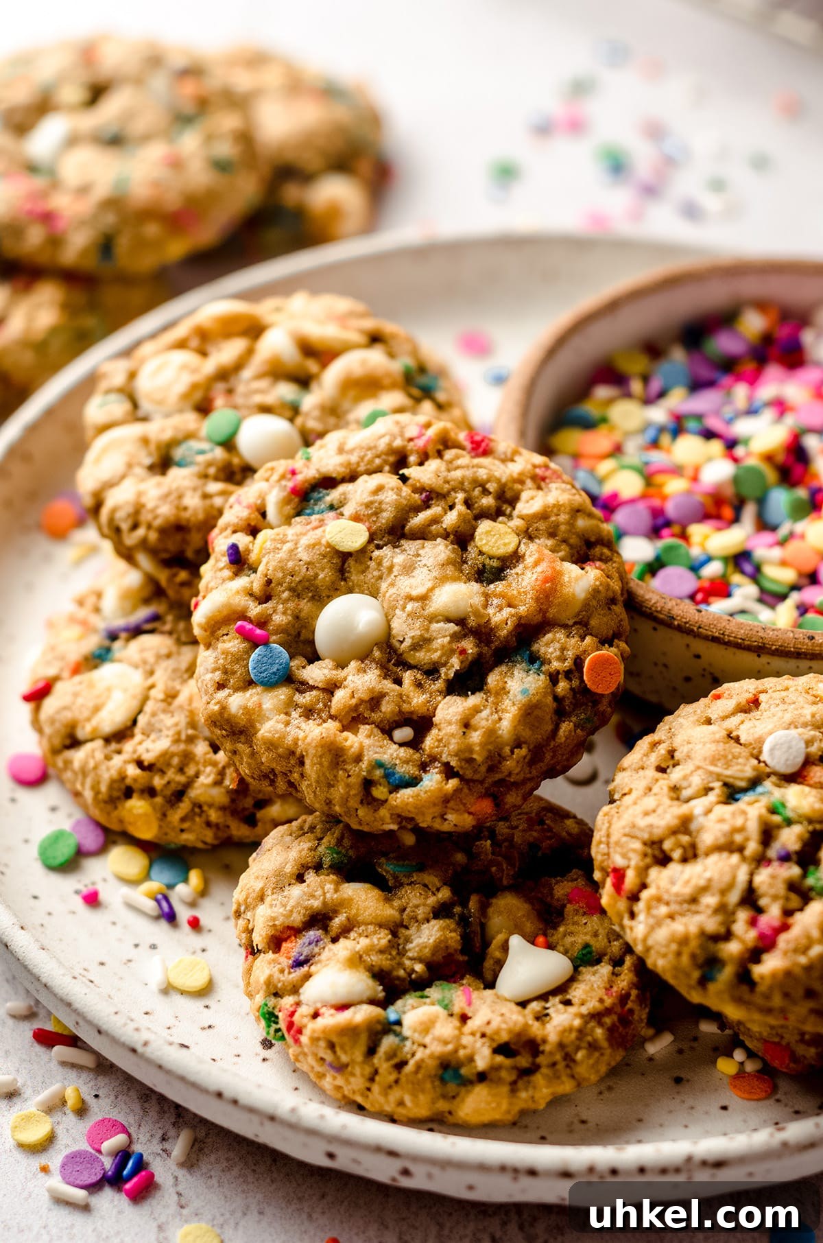 funfetti oatmeal cookies on a plate with a bowl of sprinkles