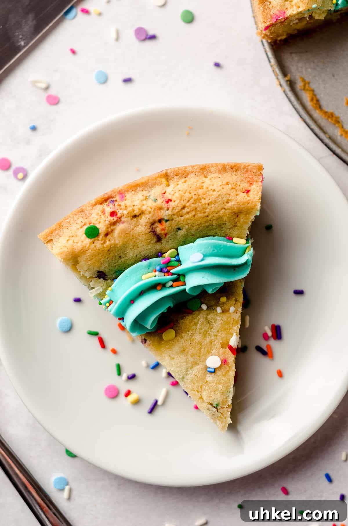 aerial photo of a slice of funfetti sugar cookie cake on a plate