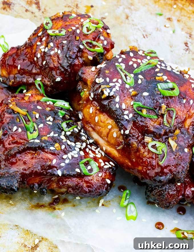Sticky Asian-Style Grilled Chicken Thighs with Sweet Glaze 6 three pieces of Sticky Asian Grilled Chicken Thighs on white background