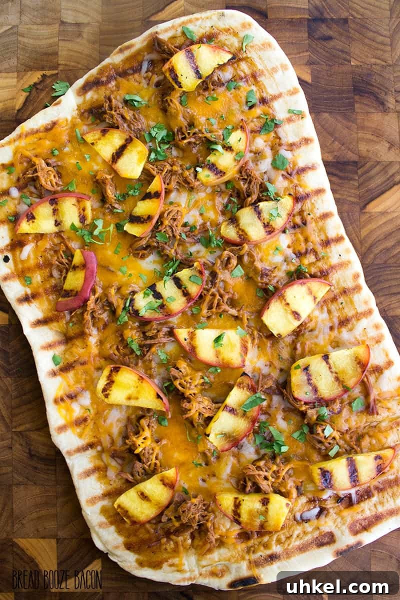 Grilled BBQ Pulled Pork & Peach Gourmet Pizza slice with melted cheese and grilled peaches