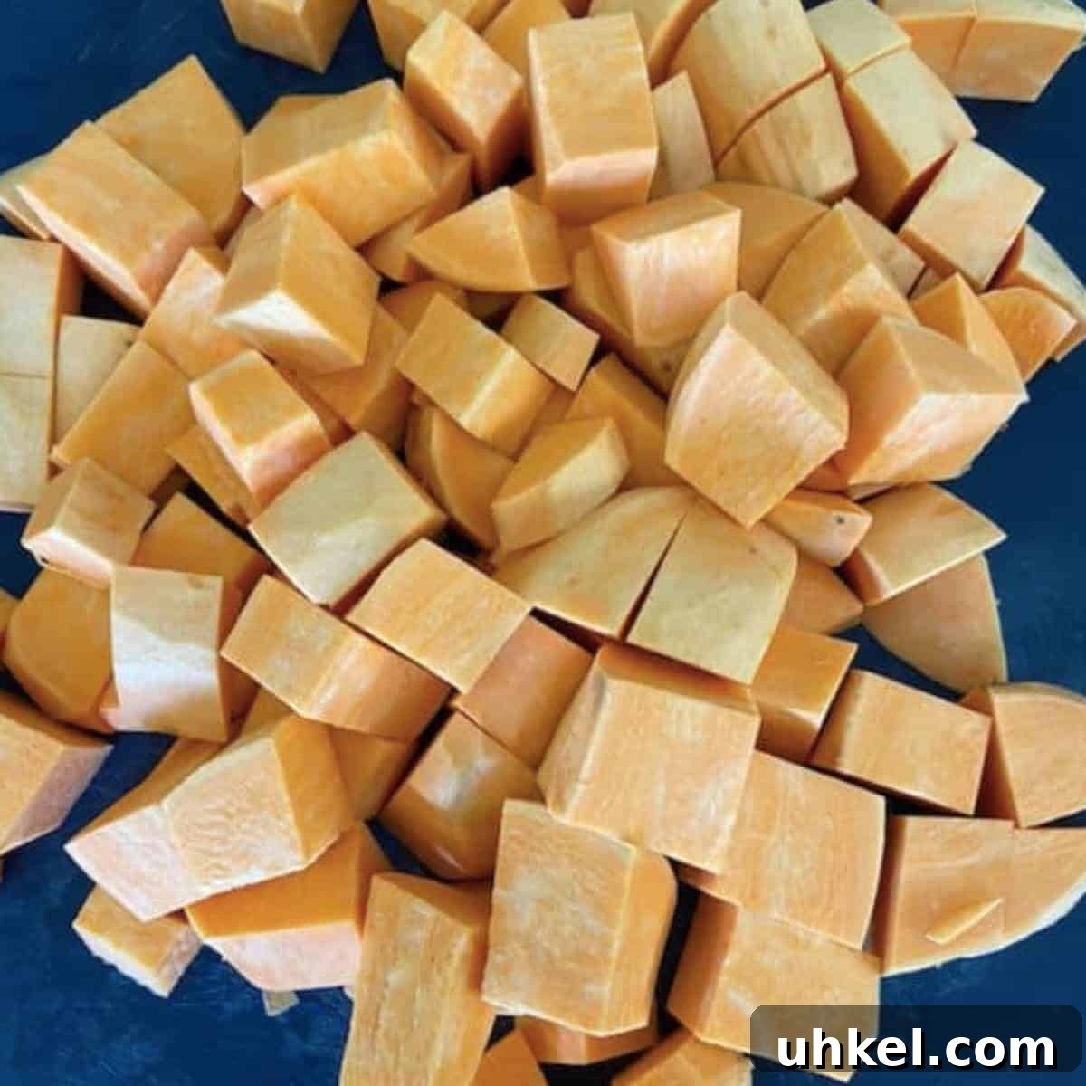 Creamy Whipped Sweet Potatoes Recipe for Holiday Sides 4 Peeled and cubed sweet potatoes on cutting board.