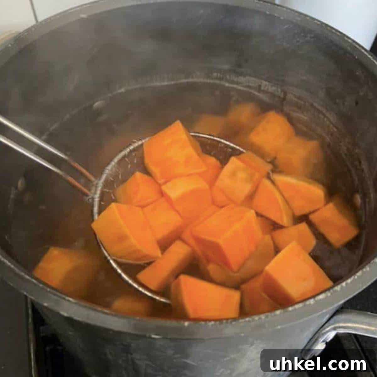 Creamy Whipped Sweet Potatoes Recipe for Holiday Sides 5 Colander stirring boiling potatoes.