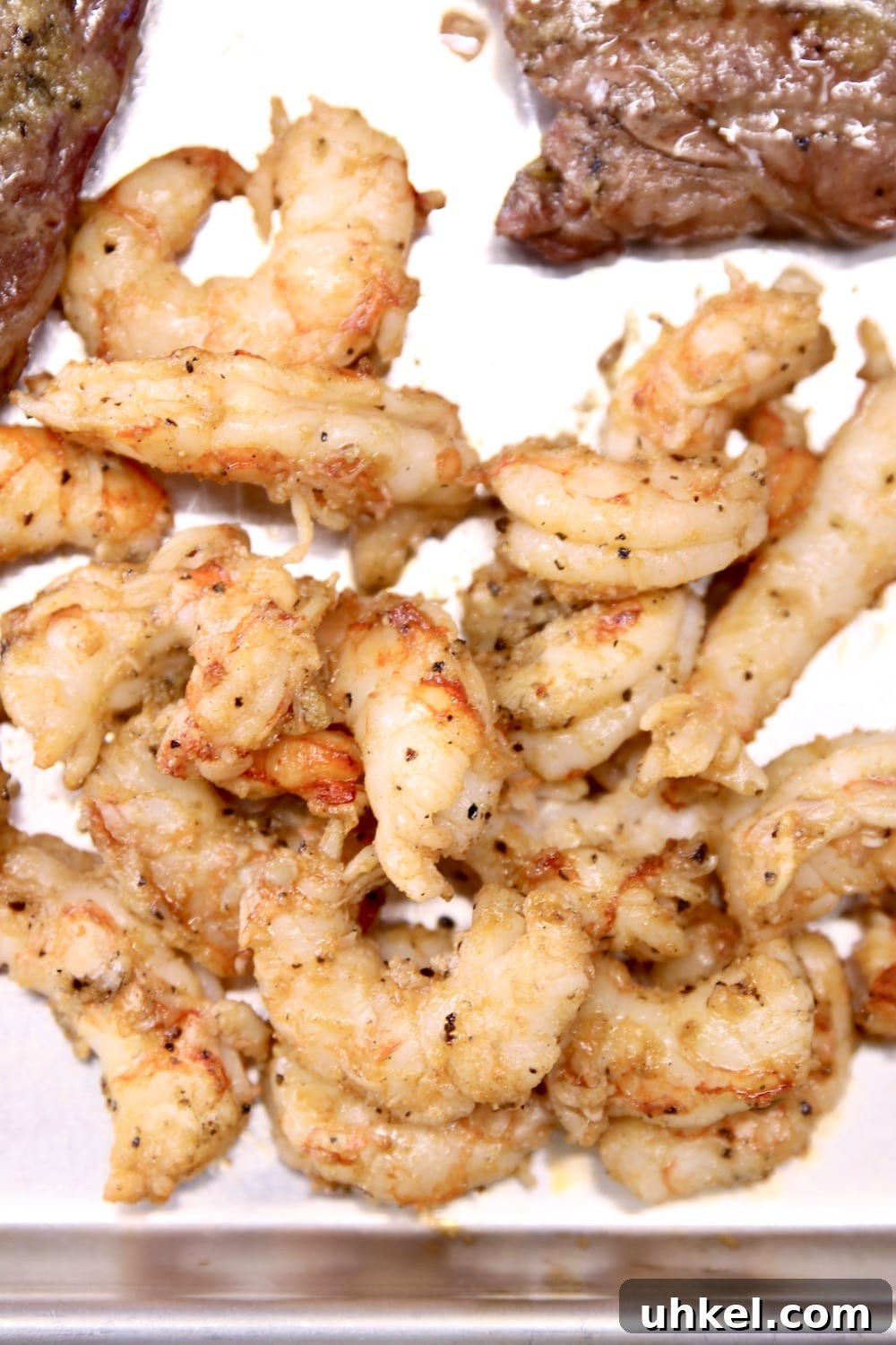 Chile-Butter Ribeye Steaks with Garlic Shrimp 2 grilled shrimp and steaks on a baking sheet