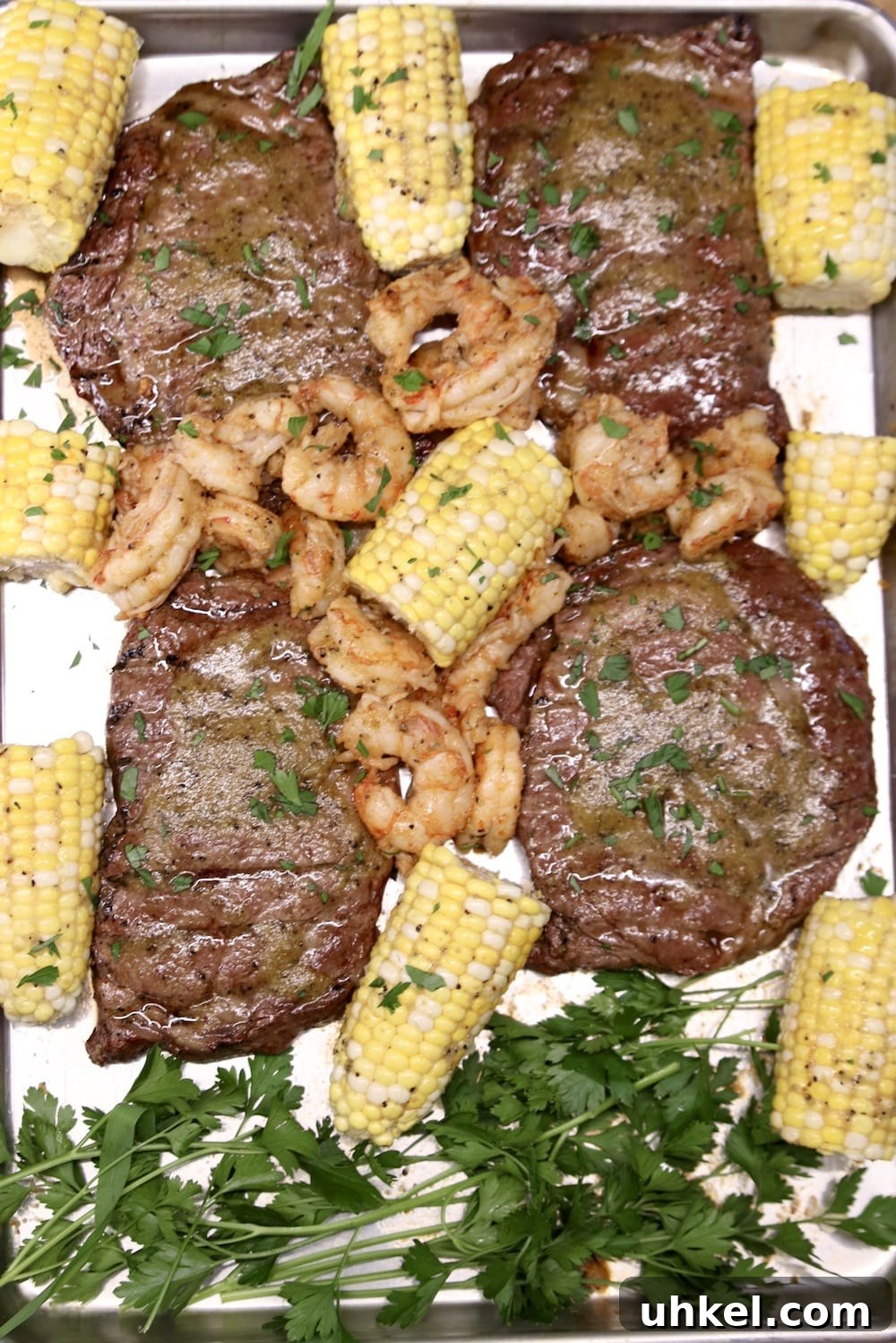 Grilled Chile Butter Ribeyes with Shrimp chile butter steaks with shrimp and corn on the cob - on a sheet pan