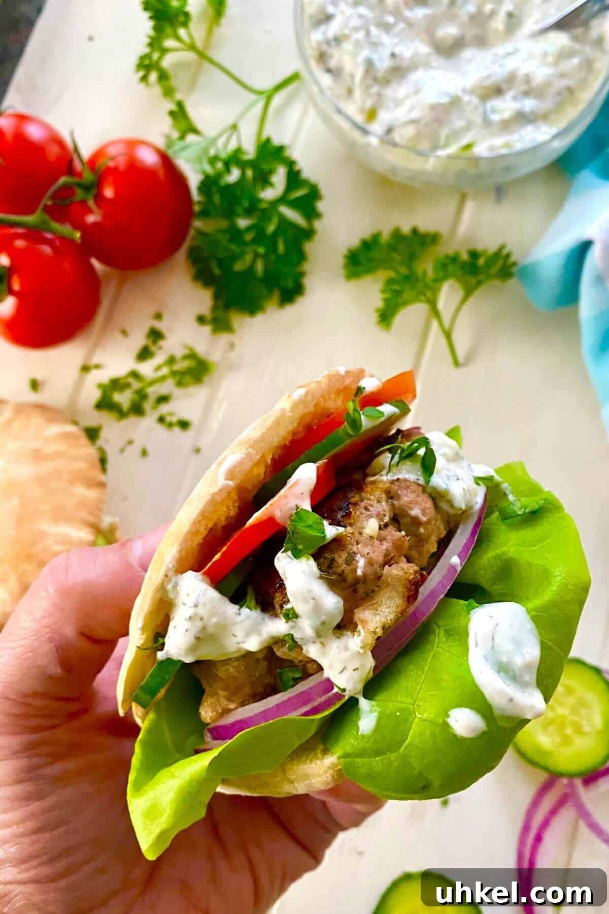 Mini Greek Turkey Sliders with Cucumber Tzatziki 8 hand holding a turkey burger.