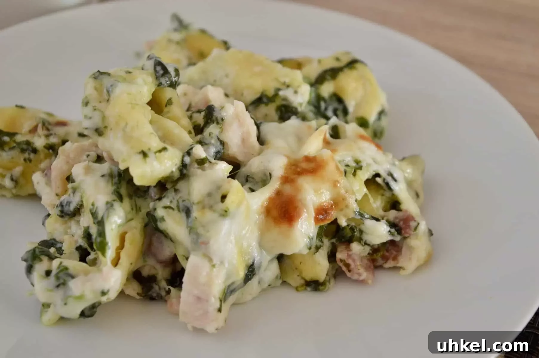 Creamy Chicken, Bacon & Spinach Tortellini Bake Recipe 9 white plate with chicken bacon spinach tortellini on it.