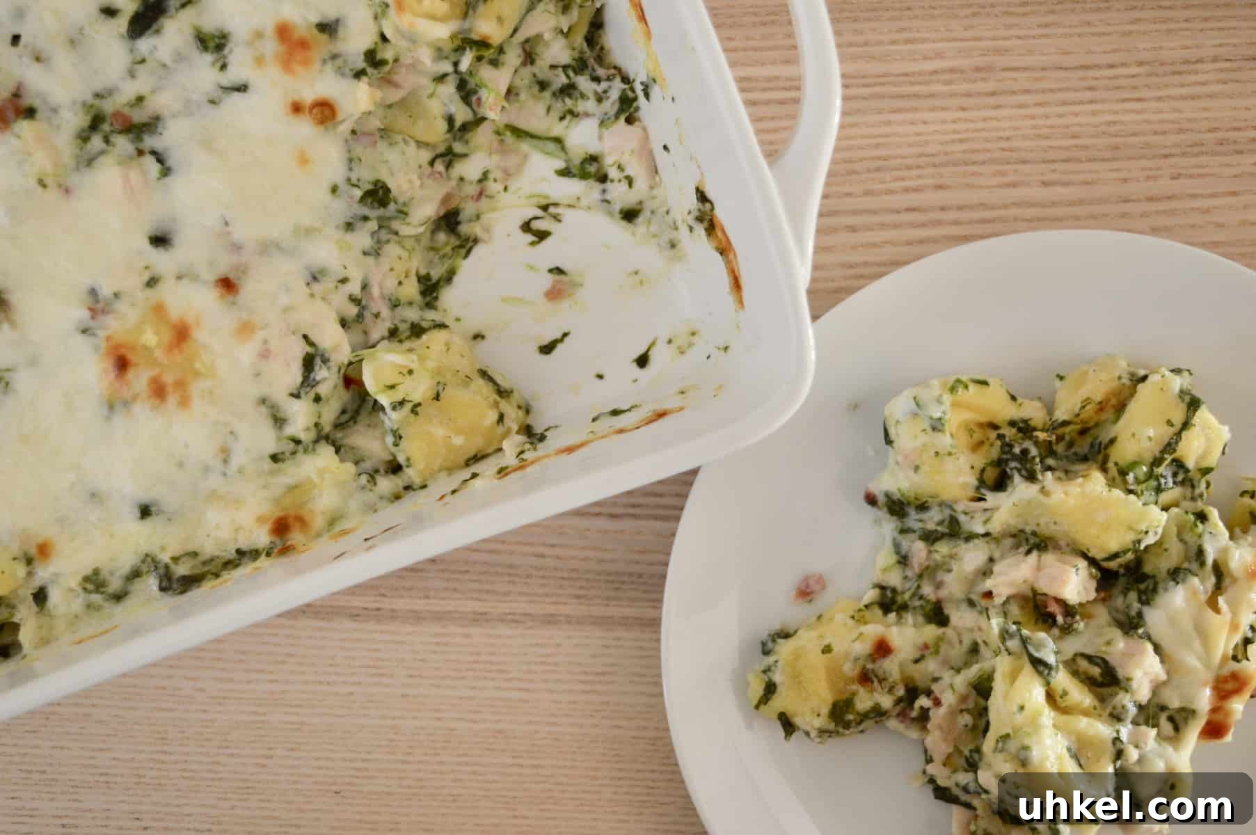 Creamy Chicken, Bacon & Spinach Tortellini Bake Recipe 3 baked tortellini casserole with a white plate.