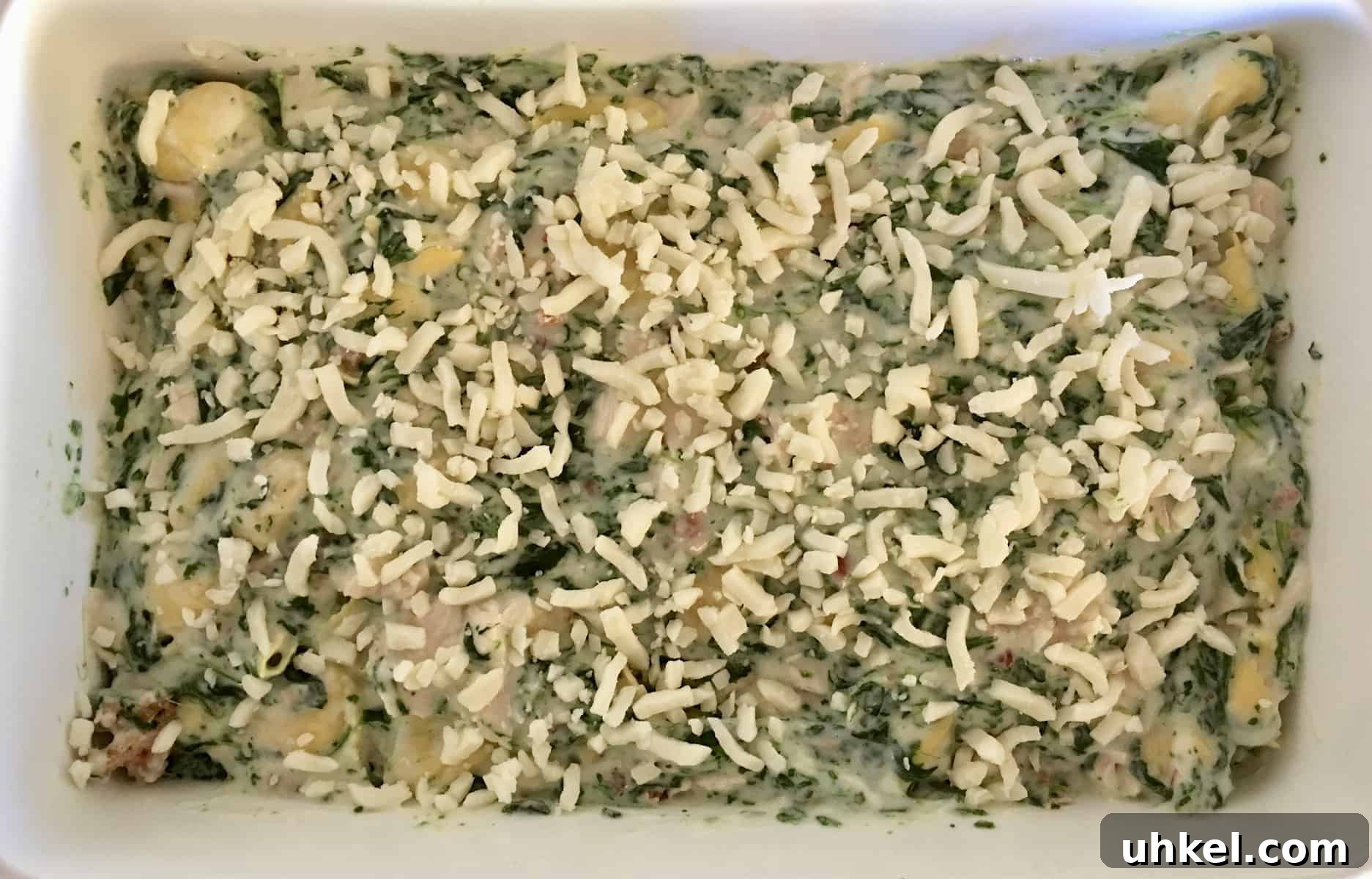 Creamy Chicken, Bacon & Spinach Tortellini Bake Recipe 7 pan of pasta with cheese on top ready to go in the oven.