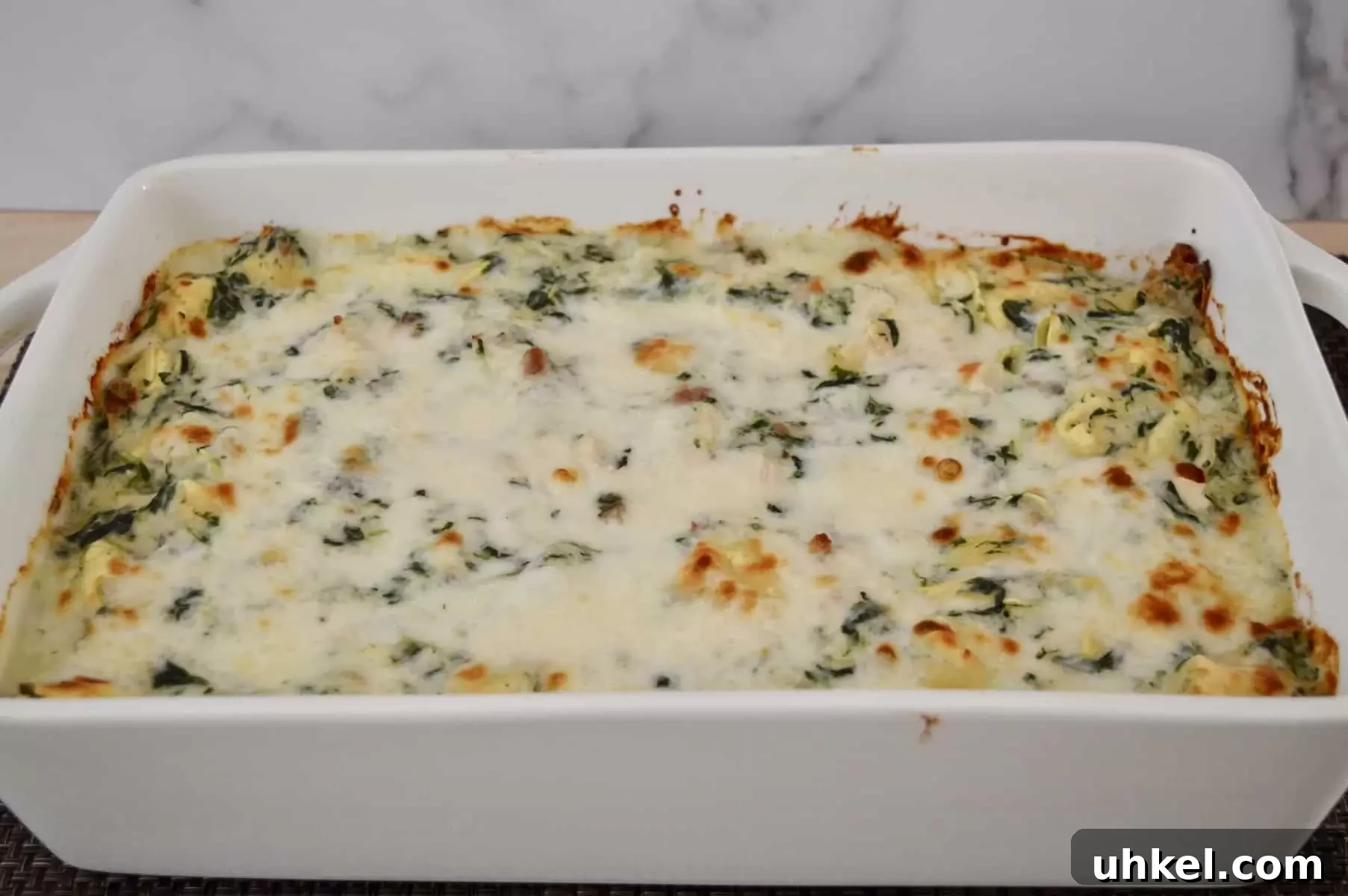 Creamy Chicken, Bacon & Spinach Tortellini Bake Recipe 8 white baking pan with chicken bacon spinach tortellini inside.