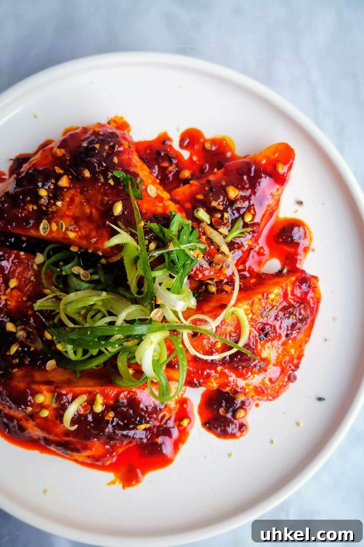 Halloumi triangles glazed with honey and harissa on a plate topped with spring onion and dukkah