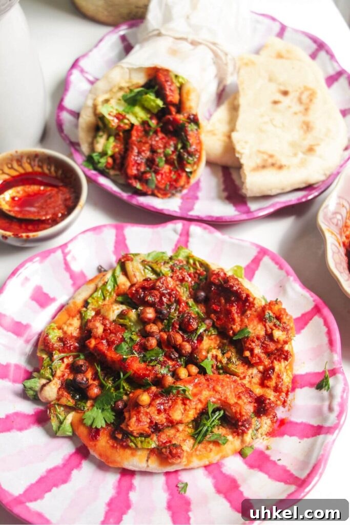 Two flatbreads with honey harissa halloumi, hummus and chickpeas on top.