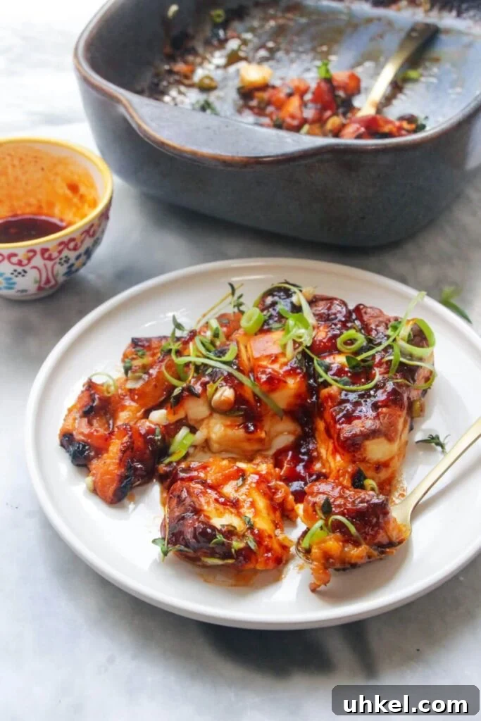 Baked whole halloumi on a small white plate with blue oven dish in the background.