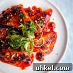 Halloumi triangles glazed with honey and harissa on a plate topped with spring onion and dukkah