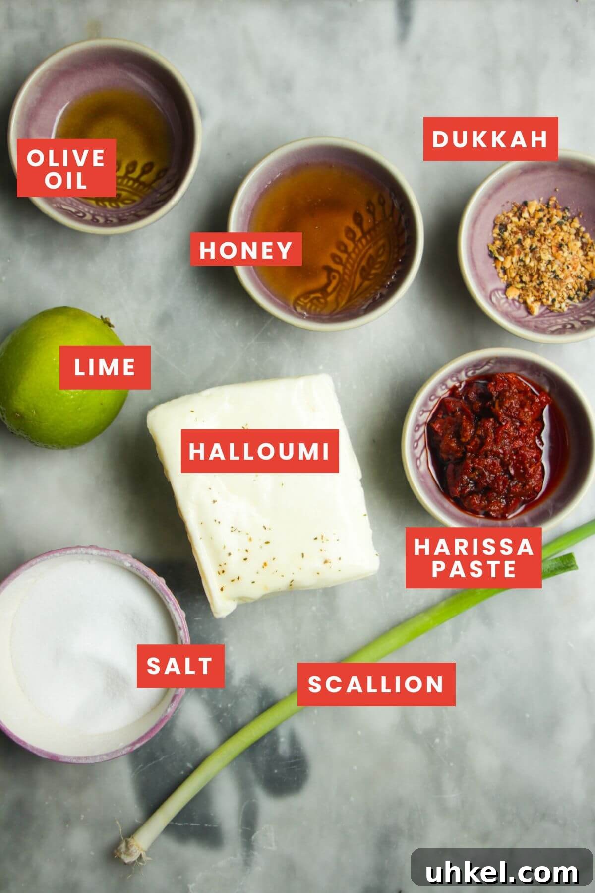 Ingredients for honey harissa halloumi laid out on a grey marble background.