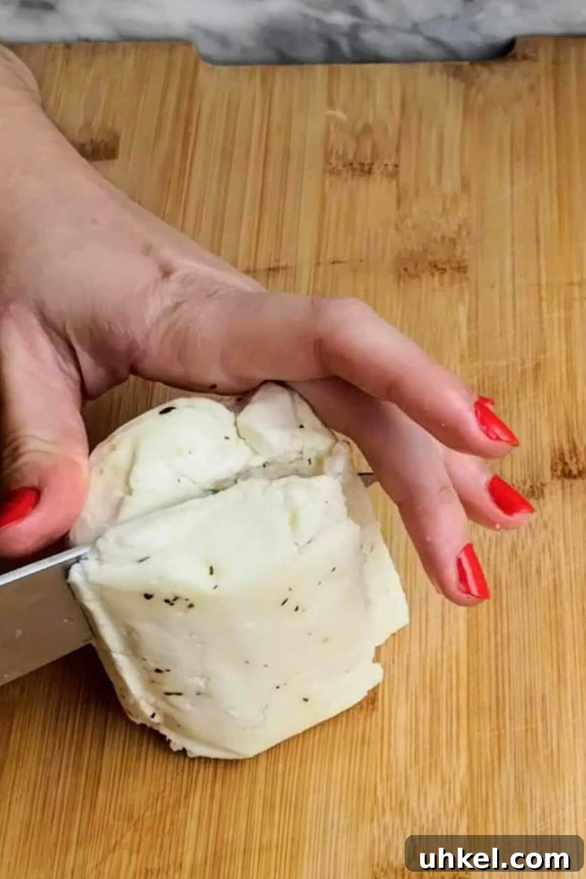 Block of halloumi being chopped in half