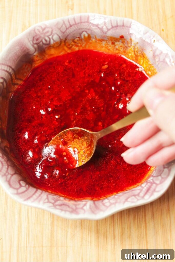 Mixing honey harissa sauce in a small pink bowl.