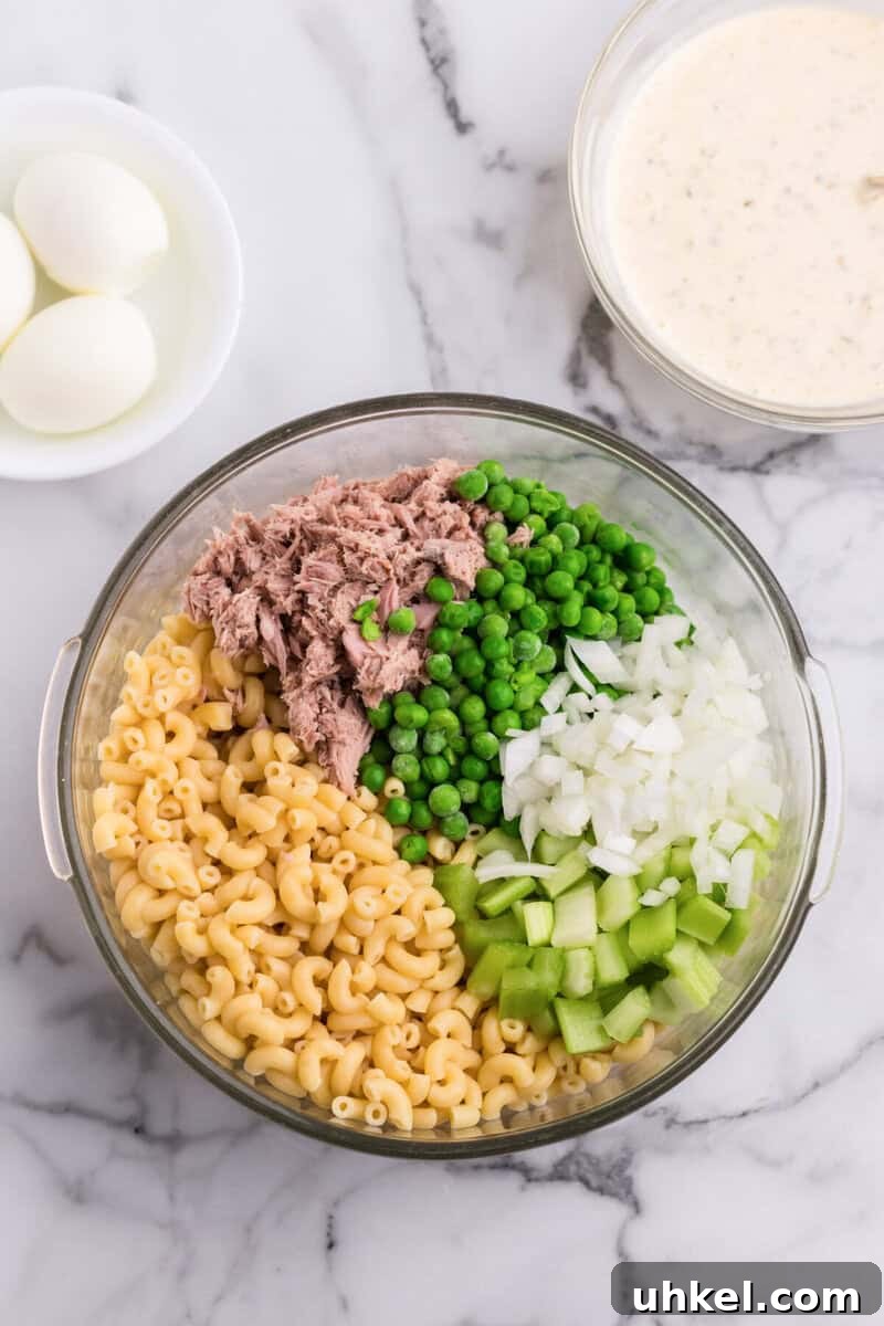 Creamy Tuna Macaroni Salad Recipe for Picnics & Potlucks 6 ingredients for the macaroni salad in large glass bowl.
