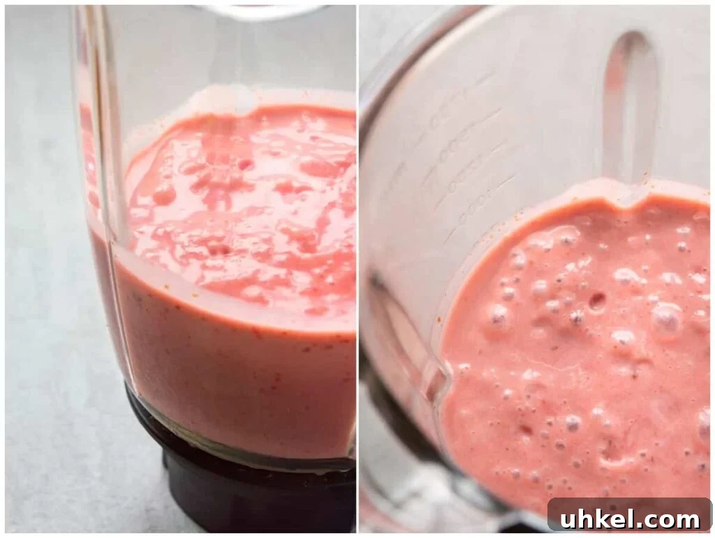 Creamy Strawberry Banana Vegan Smoothie Recipe 6 A split top-down and side-on view of a pink liquid in a blender jar