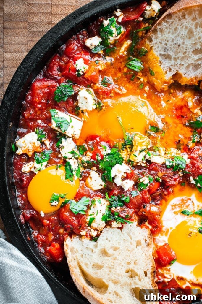 Crispy Authentic Middle Eastern Falafel Recipe 14 Harissa shakshuka with bread dipped into a very runny egg yolk in a cast iron skillet.