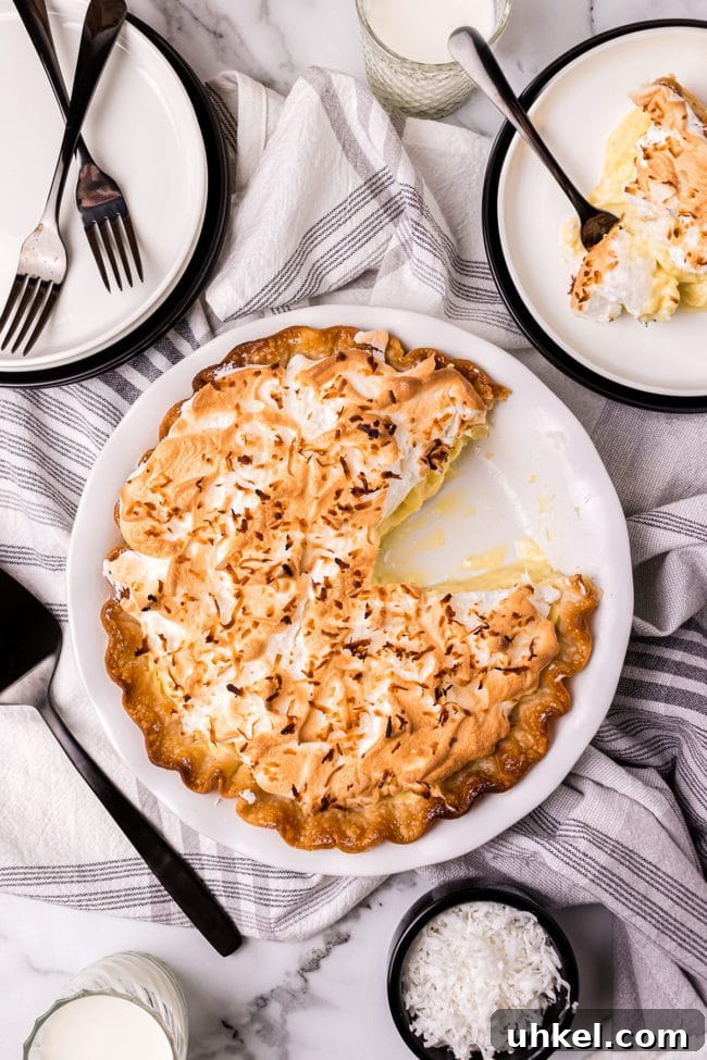 coconut pie with one serving on a plate with a fork