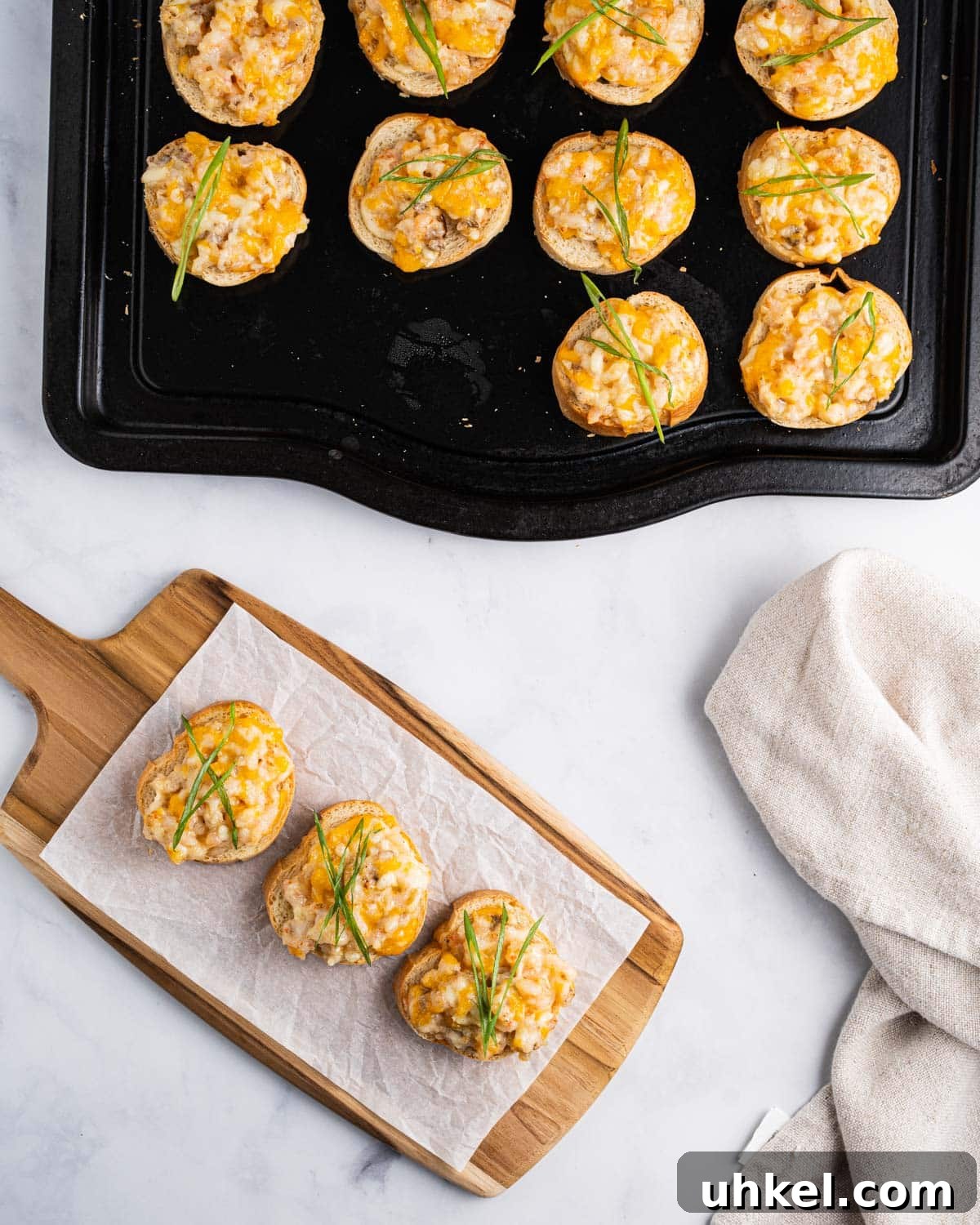 Top down of shrimp toasts on a tray and 3 on a serving board topped with green onions.