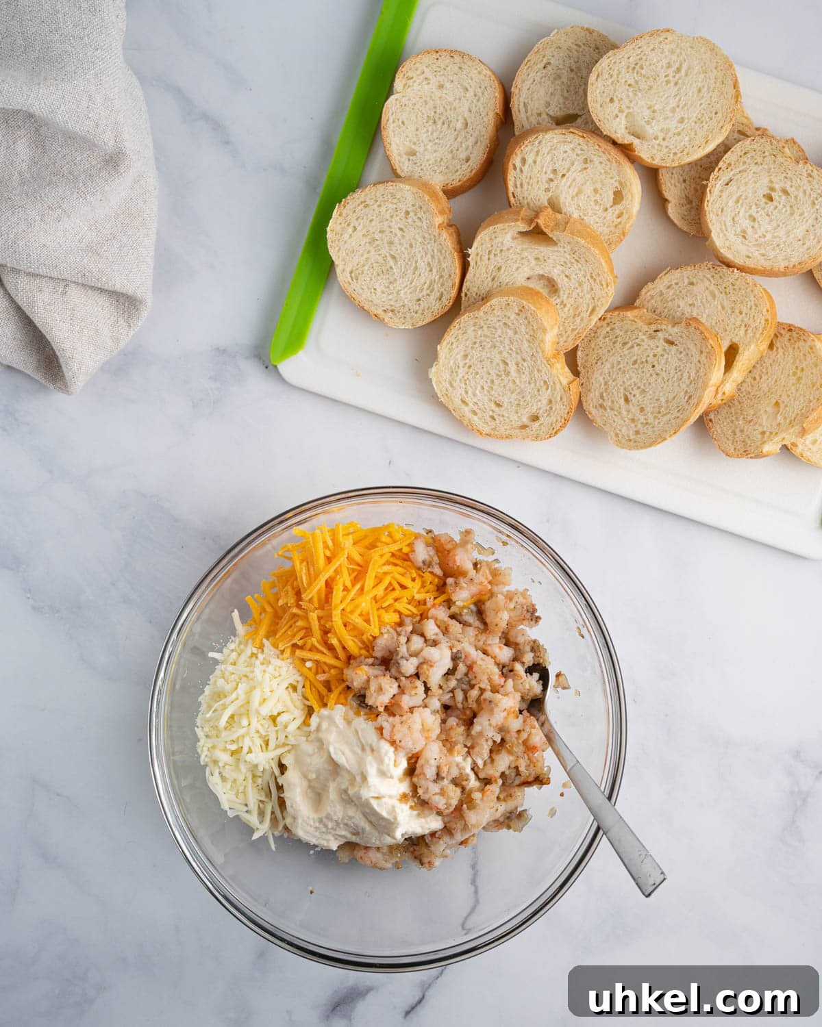 Bowl of cooked minced shrimp with mayonnaise and cheddar and mozzarella cheese.