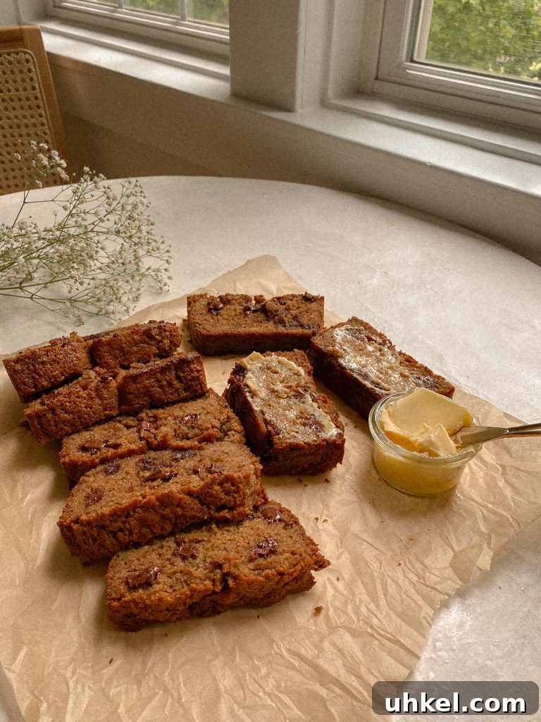 Gluten-Free Easter Brunch Menu Ideas and Recipes 6 zucchini bread slices on brown parchment paper with small bowl of butter and white flowers
