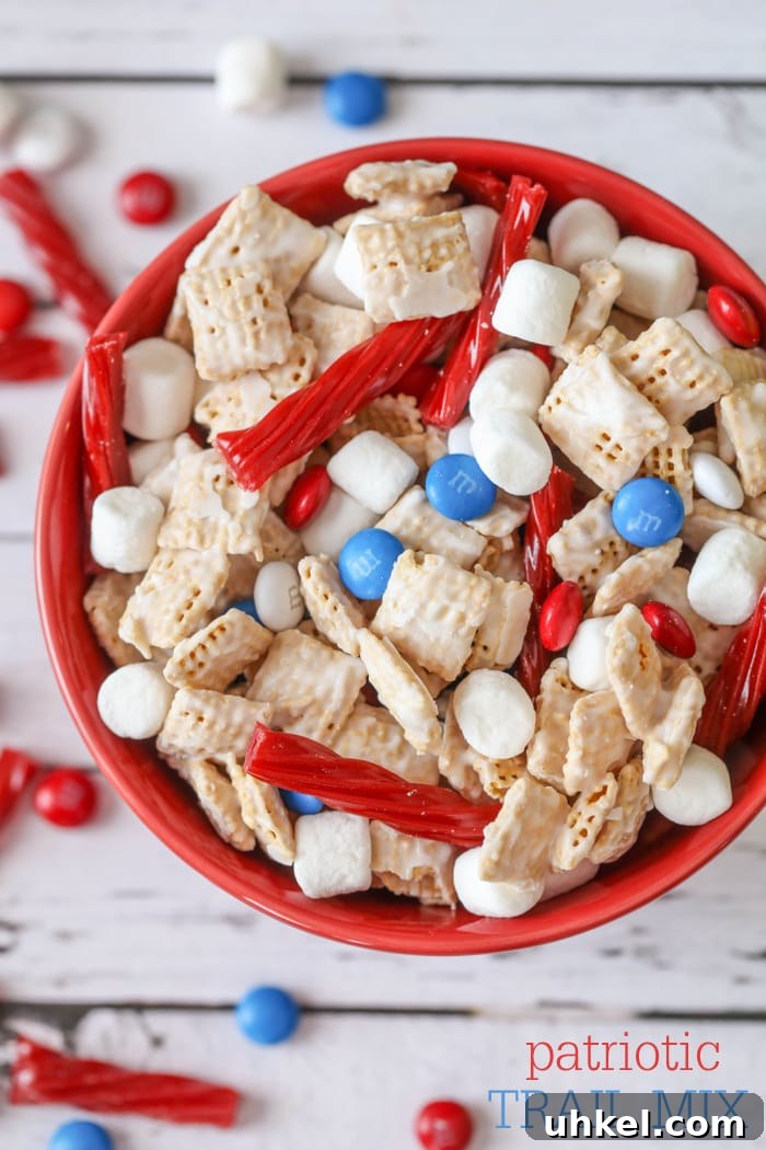 Sweet and crunchy Patriotic Trail Mix is candy coated cereal mixed with mini marshmallows, licorice and M&Ms. candy coated cereal mixed with mini marshmallows, licorice and M&Ms in a red bowl