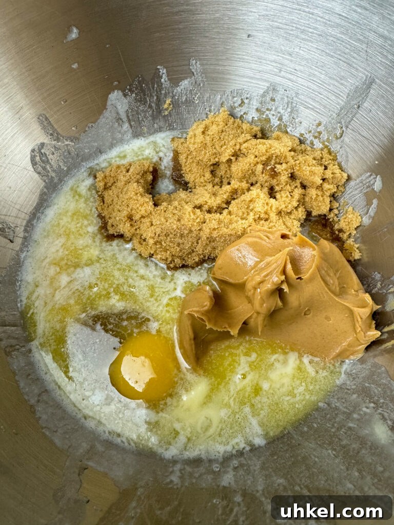 Gooey Chocolate Peanut Butter Oatmeal Bars Recipe 5 Mixing bowl with melted butter, egg, brown sugar, vanilla and peanut butter.