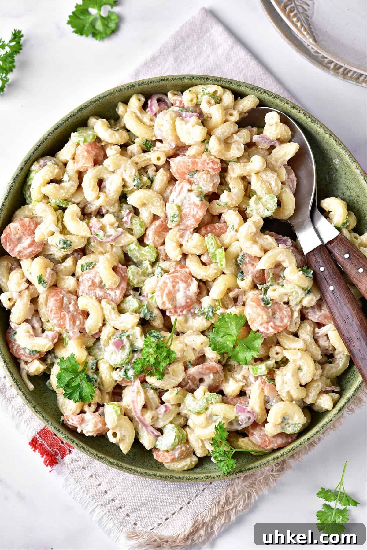 Lemon Garlic Shrimp Pasta Salad with Fresh Herbs 2 Green plate with shrimp pasta salad. White background and cloth. Parsley leaves.